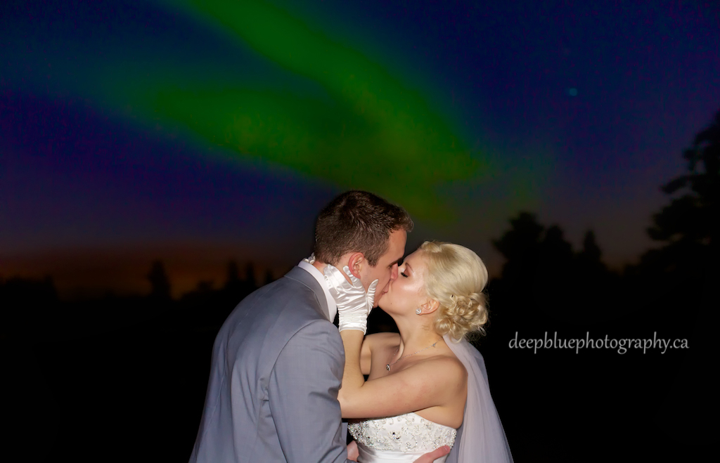Bride and Groom Kiss Under Northern Lights