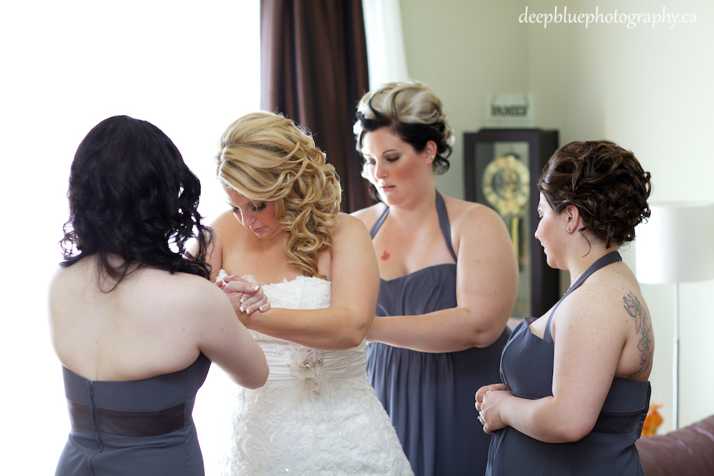 Bridesmaids Helping Bride into Dress