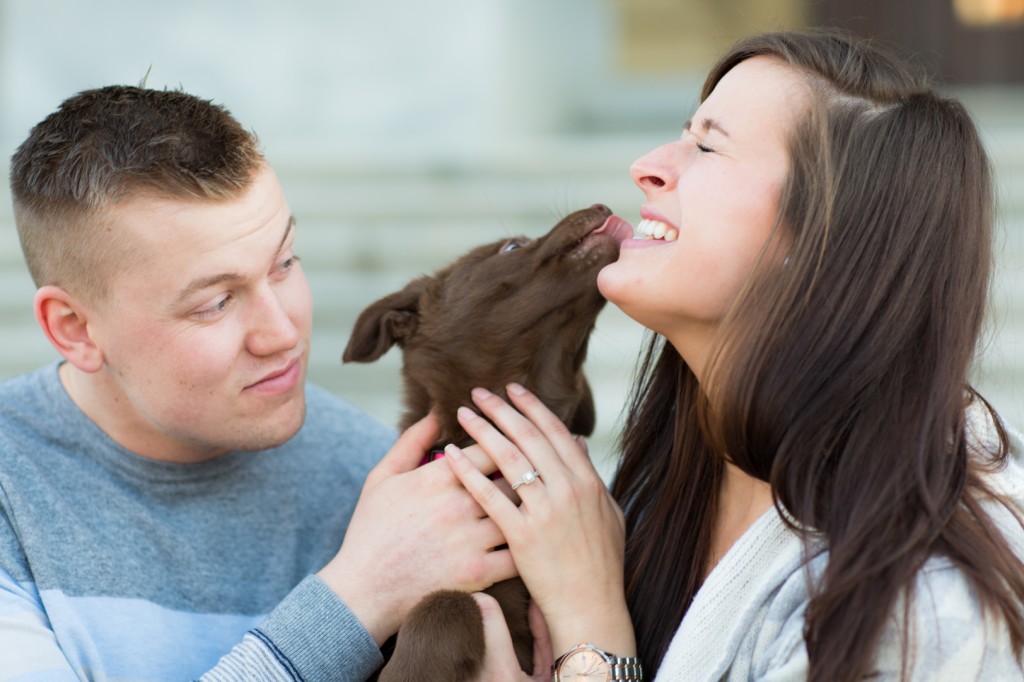 A picture of a couple getting engagement Pictures With their Dog