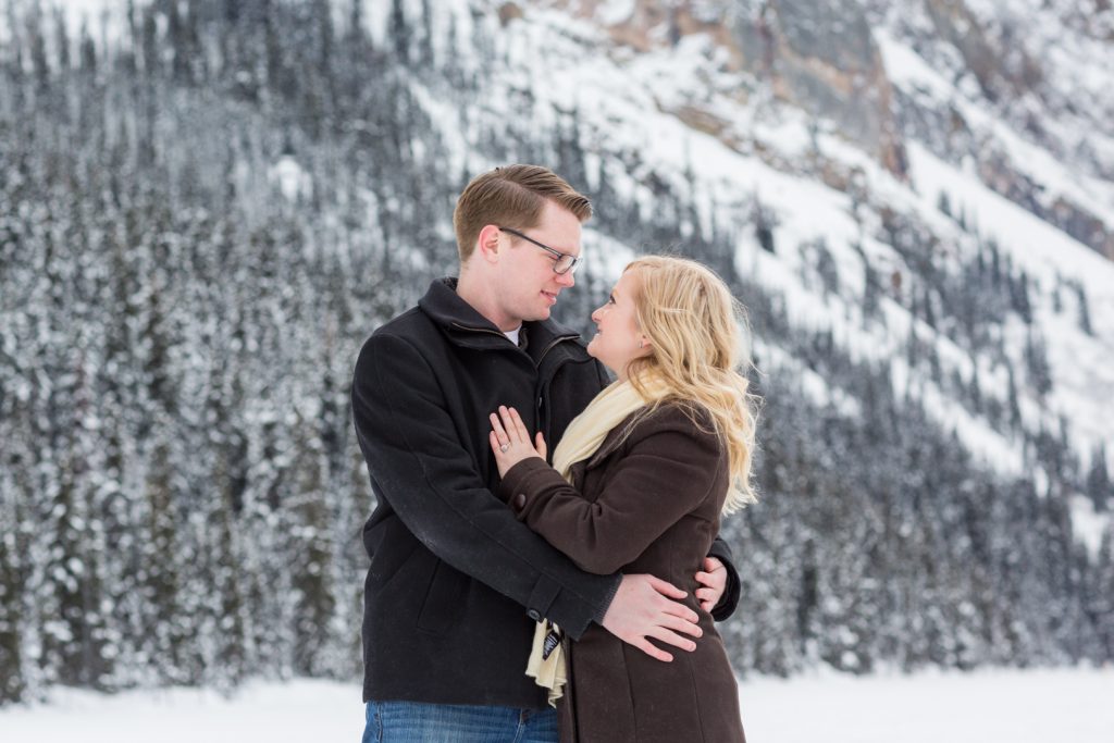 outdoor winter engagement photos with snowy trees behind