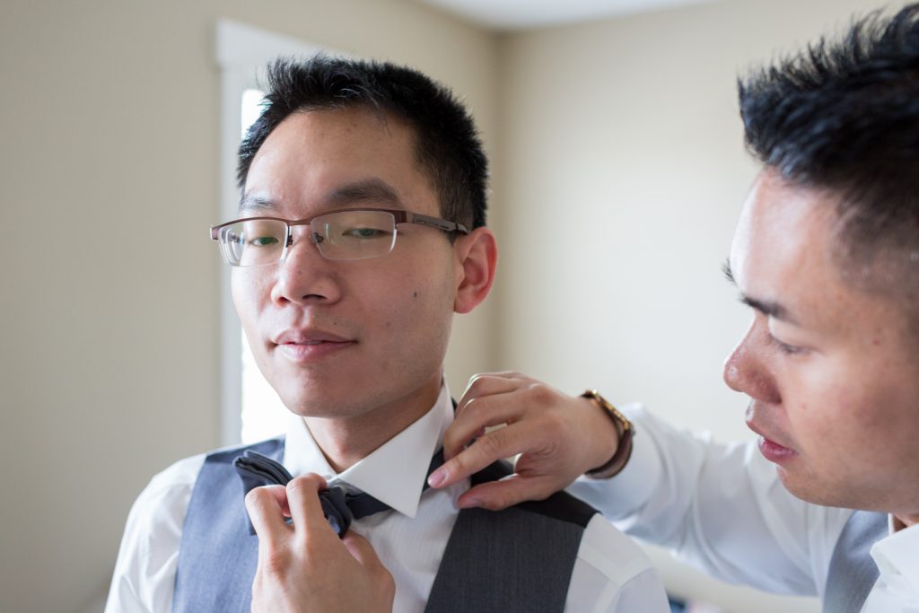 Best man helping the groom with his tie