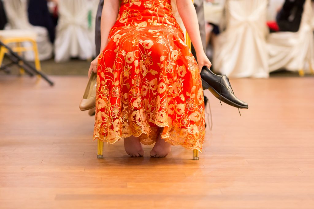Photo of bride holding onto shoes during the dinner reception shoe game 