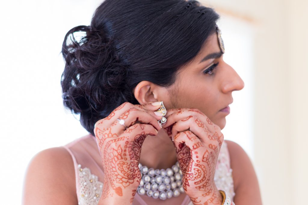 Bride putting on her jewelry and getting ready for the wedding ceremony