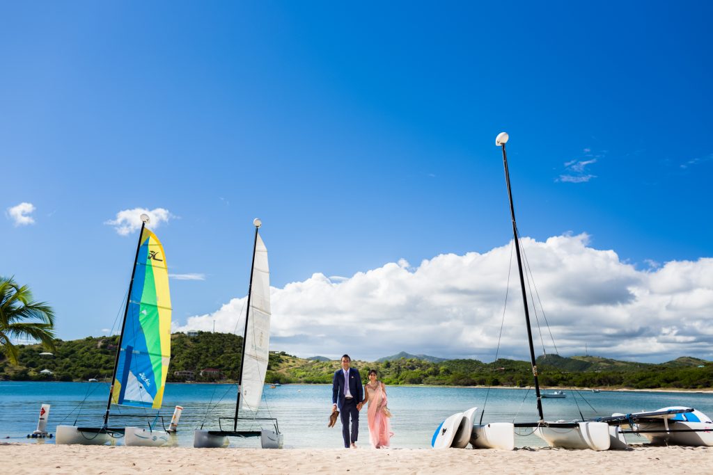 Wedding portraits taken on the beach with sailboats during this beautiful Antigua destination wedding