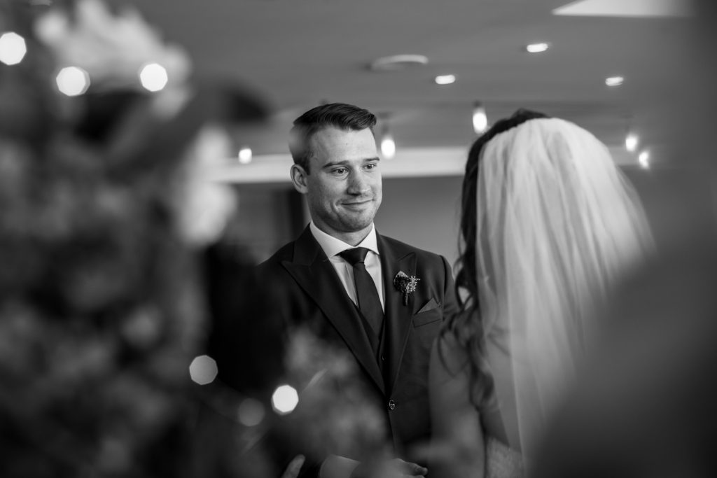 Groom looking at his bride during Shaw Conference Centre wedding ceremony
