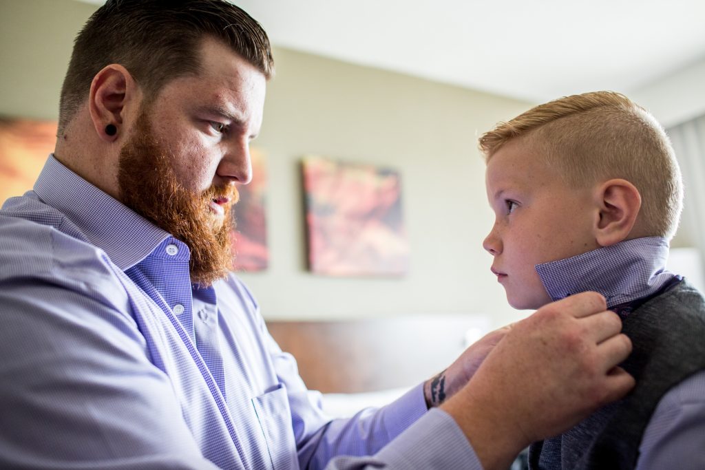 Groom helps his son with his tie before heading to Snow Valley for wedding ceremony