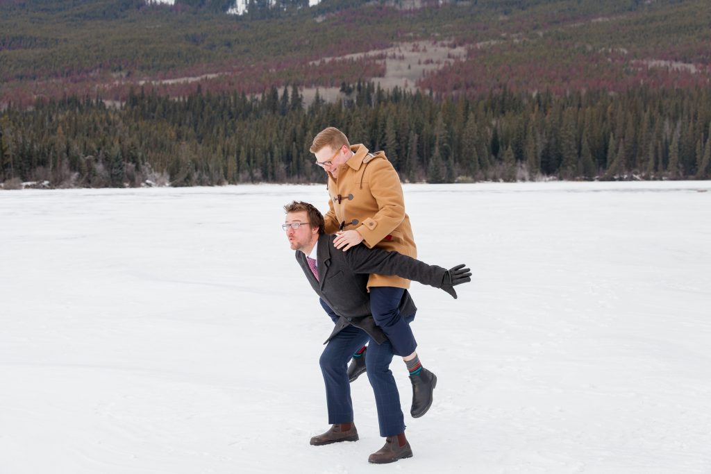 Groom and best man having some fun before the outdoor winter wedding ceremony at Pyramid Lake