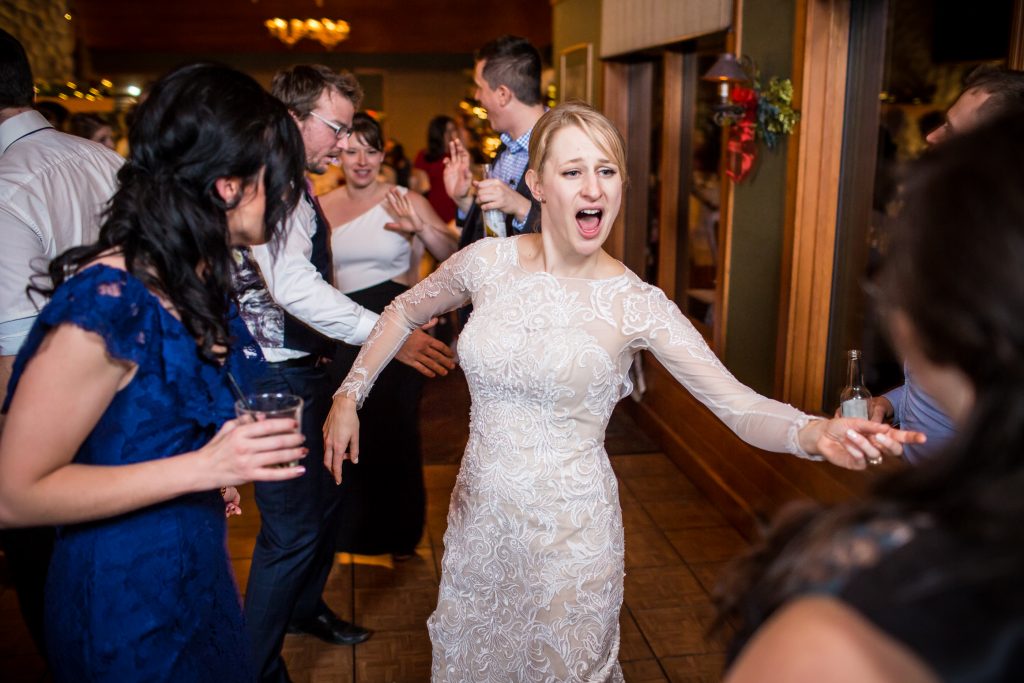 Bride dancing with her guests during indoor winter wedding reception at Pyramid Lake Resort