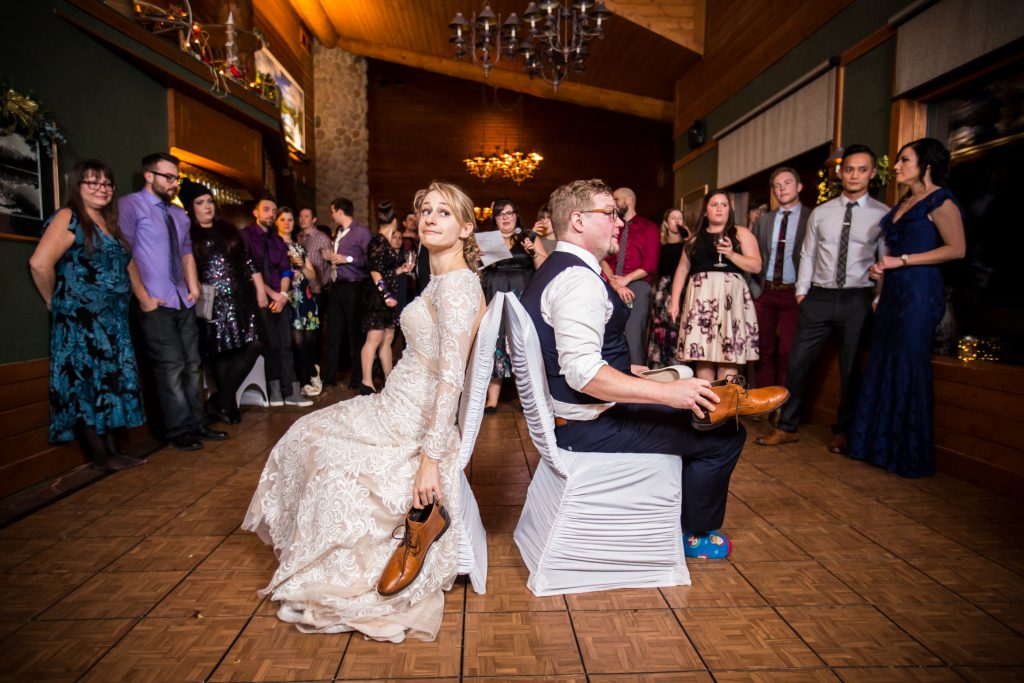 Bride and groom playing the shoe game during their winter wedding in Jasper