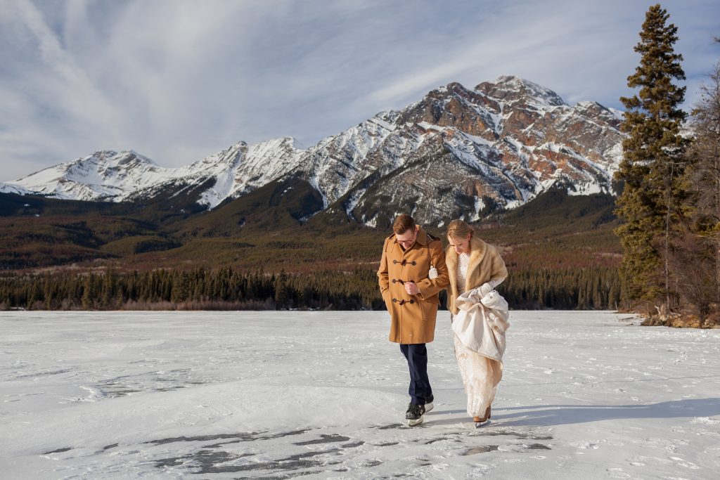 Bride and groom skating on ice mountain winter wedding