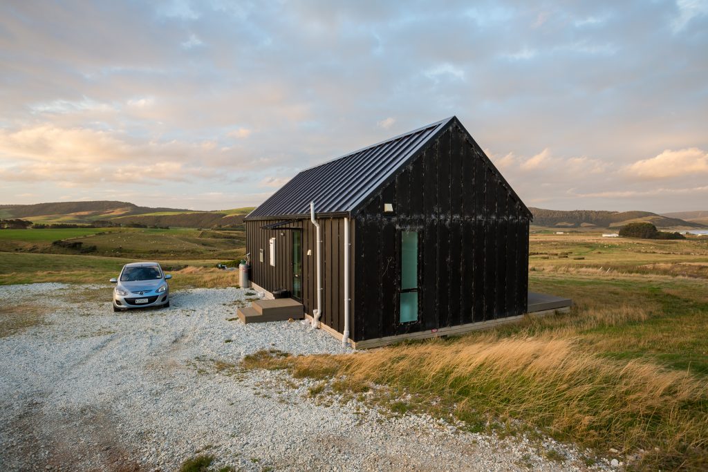 picture of the little black barn overlooking curio bay