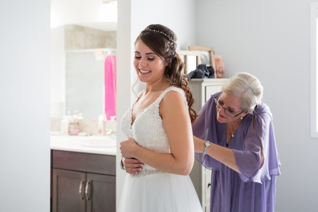 mother of the bride helping daughter get ready